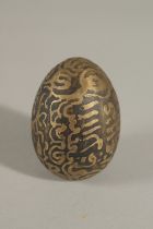 A RARE SOUTH EAST ASIAN POSSIBLY INDONESIAN TALISMANIC BRASS EGG, 6cm.