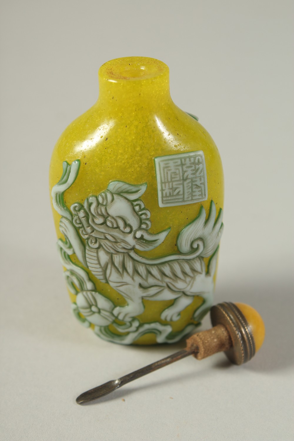 A CHINESE RELIEF-DECORATED FOO DOG SNUFF BOTTLE AND STOPPER / SPOON, 8cm high. - Image 3 of 4