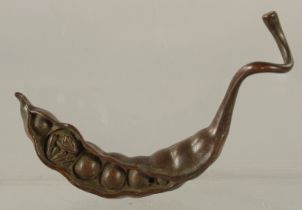 A BRONZE OKIMONO OF A PEA POD with a small frog nestled inside, 9cm long.