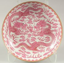 A LARGE CHINESE PINK AND WHITE GLAZED PORCELAIN DRAGON PLATE, with two finely painted dragons and