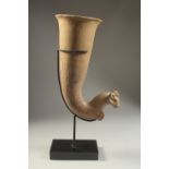 A LARGE POTTERY GOAT FORMED RHYTON, elevated on a purpose-made stand, rhyton 32cm high.