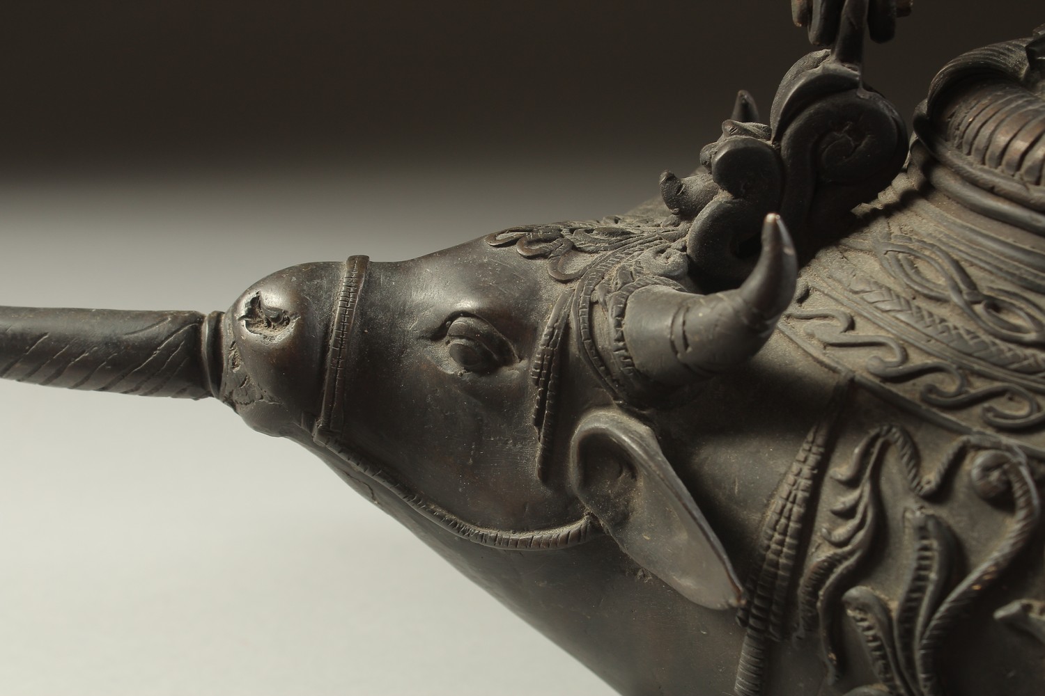 A FINE AND UNUSUAL INDIAN BRONZE EWER, with bulls' head spout and relief hindu deities around the - Image 5 of 5