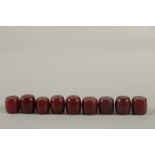 A COLLECTION OF LARGE RED BAKELITE - POSSIBLY CHERRY AMBER BARREL-SHAPED BEADS, combined weight