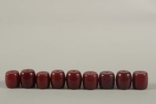 A COLLECTION OF LARGE RED BAKELITE - POSSIBLY CHERRY AMBER BARREL-SHAPED BEADS, combined weight