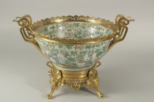 A 19TH CENTURY CHINESE CANTON FAMILLE VERTE PORCELAIN BOWL, heightened with decorative brass mounts,