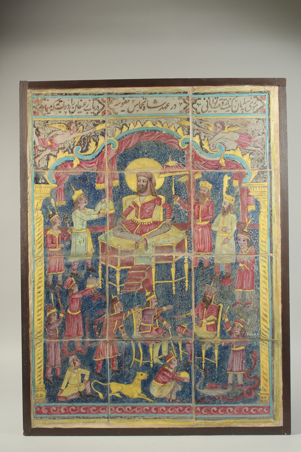 A FINE EARLY 19TH CENTURY PERSIAN QAJAR GLAZED POTTERY TWELVE-TILE PANEL, depicting enthroned