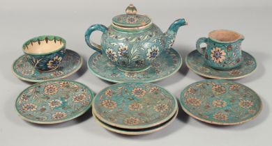 A PALESTINIAN TURQUOISE GLAZE POTTERY PART TEA SET, each piece painted with floral decoration,