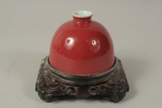 A CHINESE COPPER RED PORCELAIN WATER POT, with fitted carved hardwood stand, water pot 12cm
