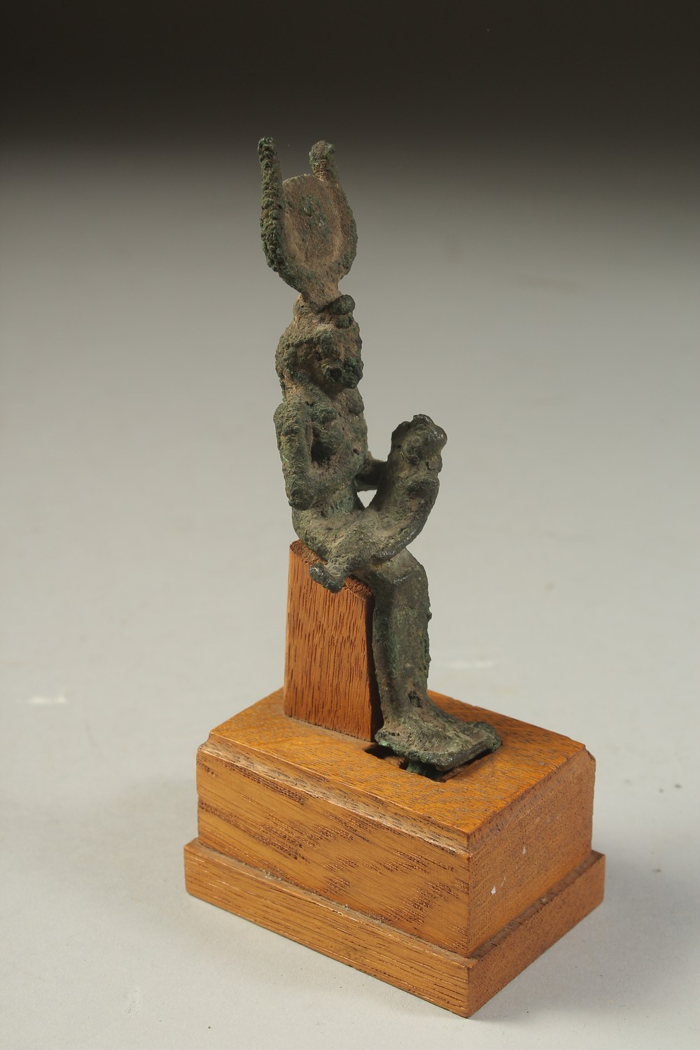 A RARE ANCIENT EYGPTIAN BRONZE FIGURE OF ISIS NURTURING HORUS, on a wooden stand, bronze 12cm high. - Image 2 of 4