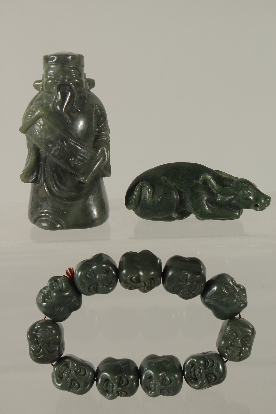 A COLLECTION OF THREE CARVED GREEN HARDSTONE PIECES, (3).