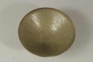 A CHINESE CELADON GLAZED POTTERY BOWL, the interior with carved children amongst vines, 18.5cm