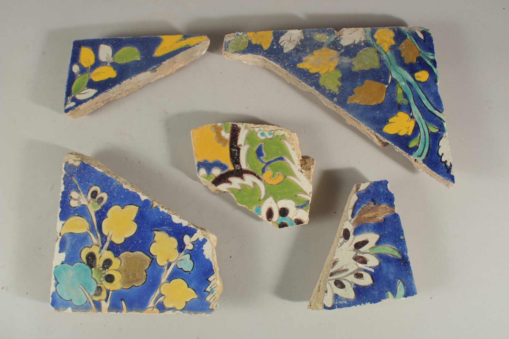 COLLECTION OF FIVE 17TH CENTURY PERSIAN SAFAVID TILES FRAGMENTS, (5).