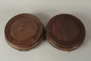 A VERY LARGE PAIR OF CHINESE CARVED HARDWOOD CIRCULAR STANDS, with a band of carved wave pattern