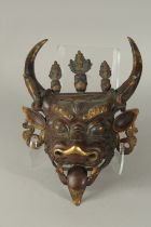 A 19TH CENTUTY TIBETAN OR CHINESE GILDED BRONZE BULL DEMON MASK, the horns with coiled snakes and