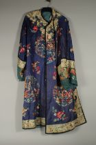 A CHINESE EMBROIDERED BLUE SILK ROBE, adorned with threaded floral sprays and panels of figures.
