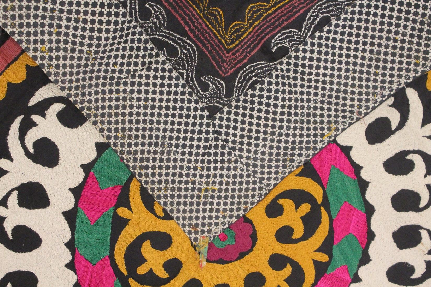 AN UZBEK SUZANI EMBROIDERED TEXTILE, with central foliate motif in yellow, green, maroon, black, and - Image 3 of 3