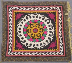 AN UZBEK SUZANI EMBROIDERED TEXTILE, with central foliate motif in yellow, green, maroon, black, and