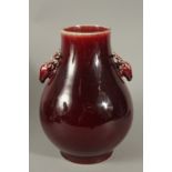 A CHINESE OX BLOOD GLAZE PORCELAIN VASE, with dear head handles, character mark to base, 30cm high.