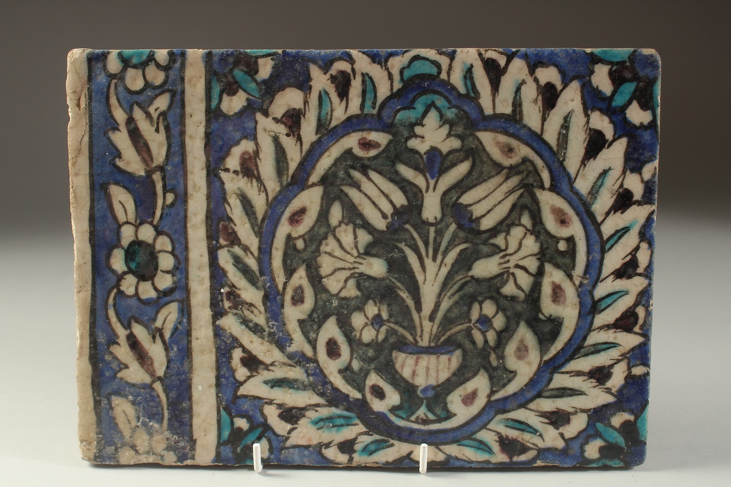 A FINE 17TH CENTURY OTTOMAN DAMASCUS GLAZED POTTERY TILE, with a large lotus flower, tulips and