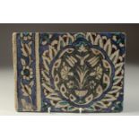 A FINE 17TH CENTURY OTTOMAN DAMASCUS GLAZED POTTERY TILE, with a large lotus flower, tulips and