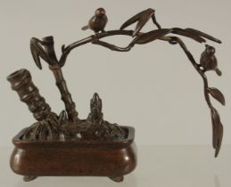 A BRONZE OKIMONO OF A BIRD stood on the branch of a planted tree, 10cm wide.