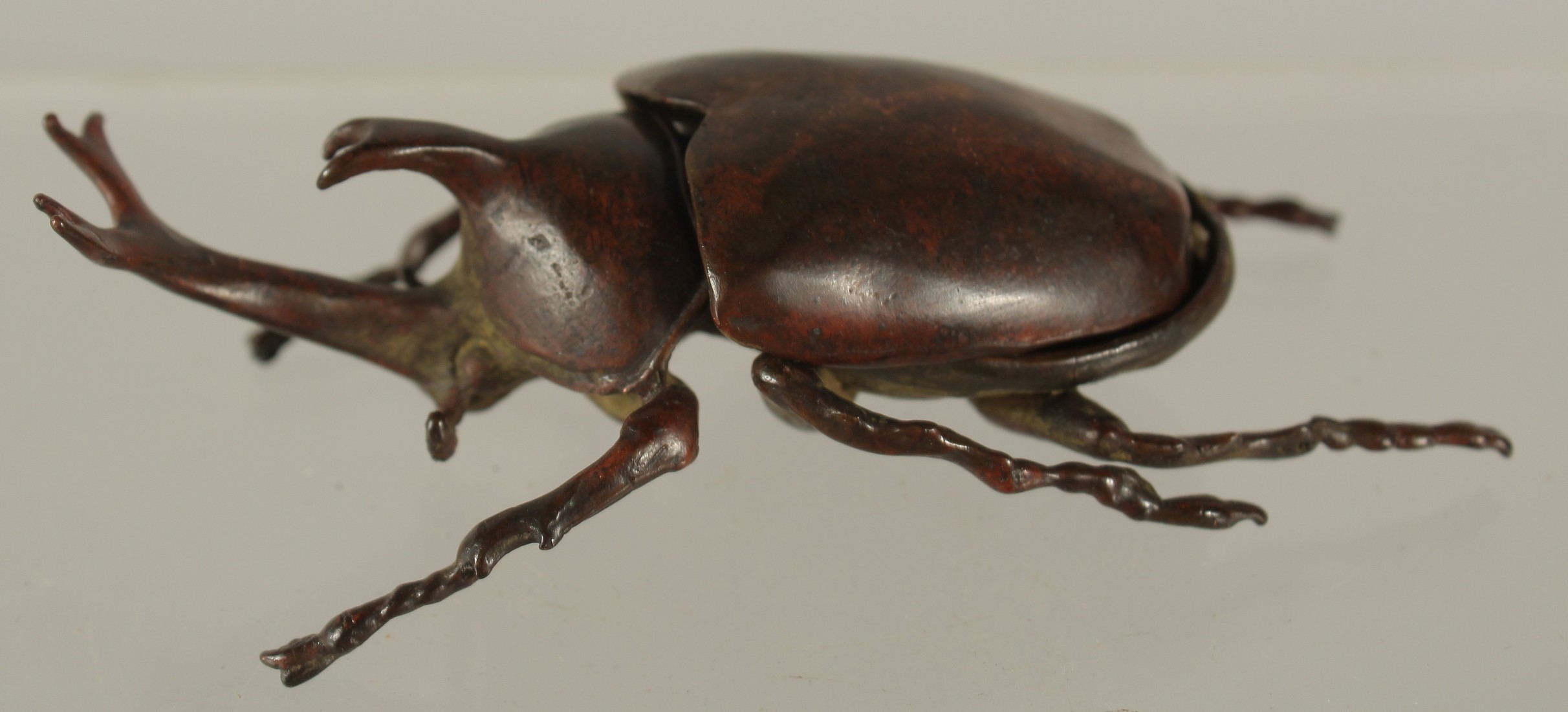 A BRONZE OKIMONO OF A RHINO BEETLE, with removable wings, 9cm long.