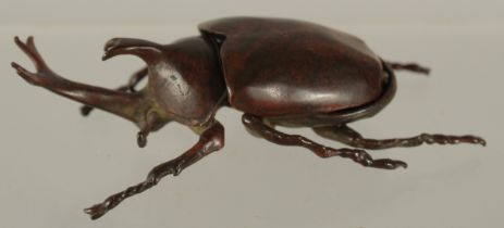 A BRONZE OKIMONO OF A RHINO BEETLE, with removable wings, 9cm long.