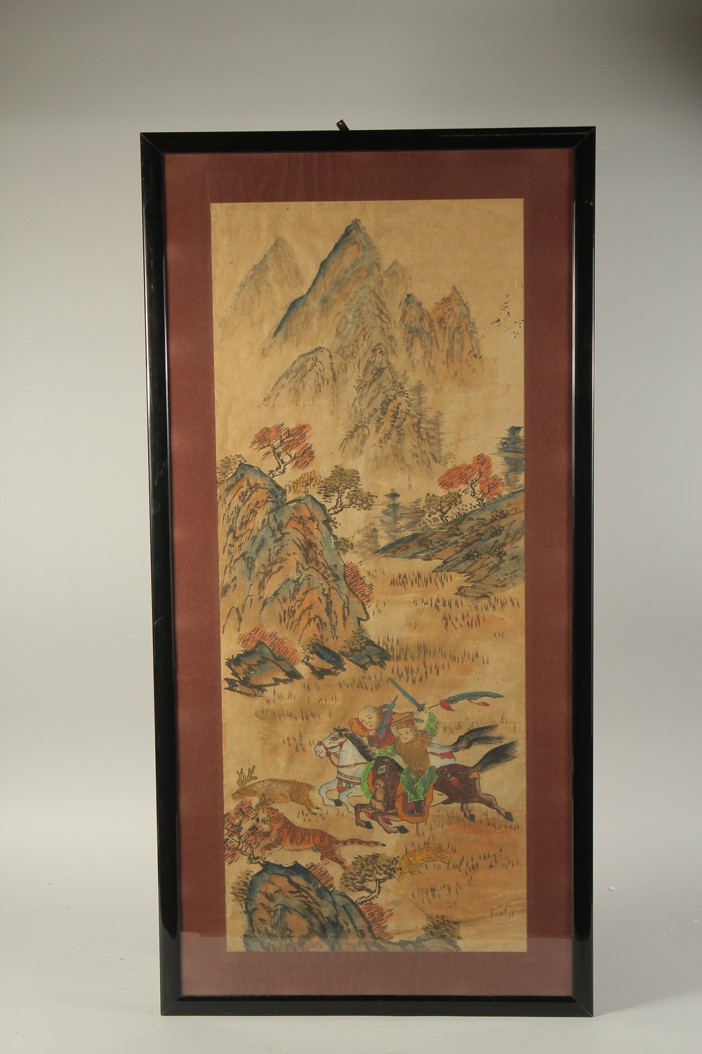 A CHINESE PAINTING ON PAPER, depicting hunters on horseback chasing a tiger within a mountainous