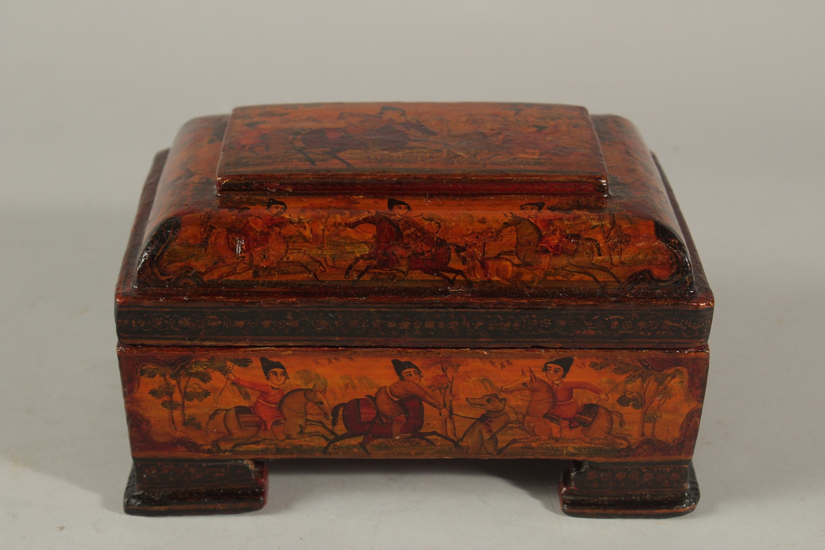 A FINE 19TH CENTURY PERSIAN QAJAR PAINTED AND LACQUERED PAPER MACHE BOX, raised on four feet, 18cm x