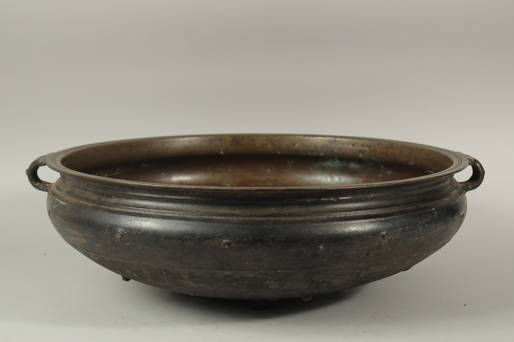 A LARGE 19TH CENTURY INDIAN OR SOUTH EAST ASIAN BRONZE TWIN HANDLE URLI, 59cm diameter. *Note: a