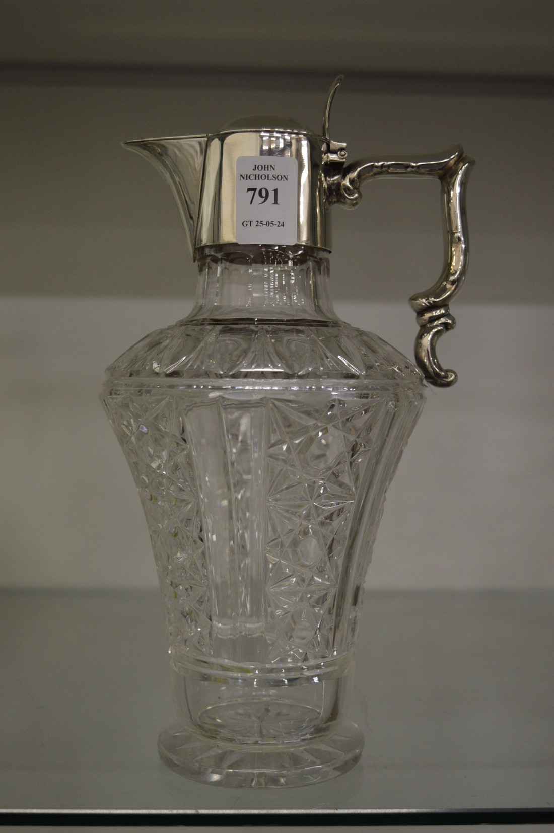 Cut glass claret jug with silver mounts.