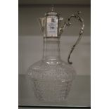 Cut glass claret jug with silver mounts.