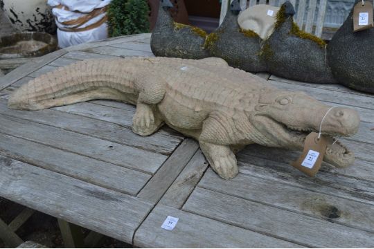 A reconstituted stone ornament modelled as a crocodile.