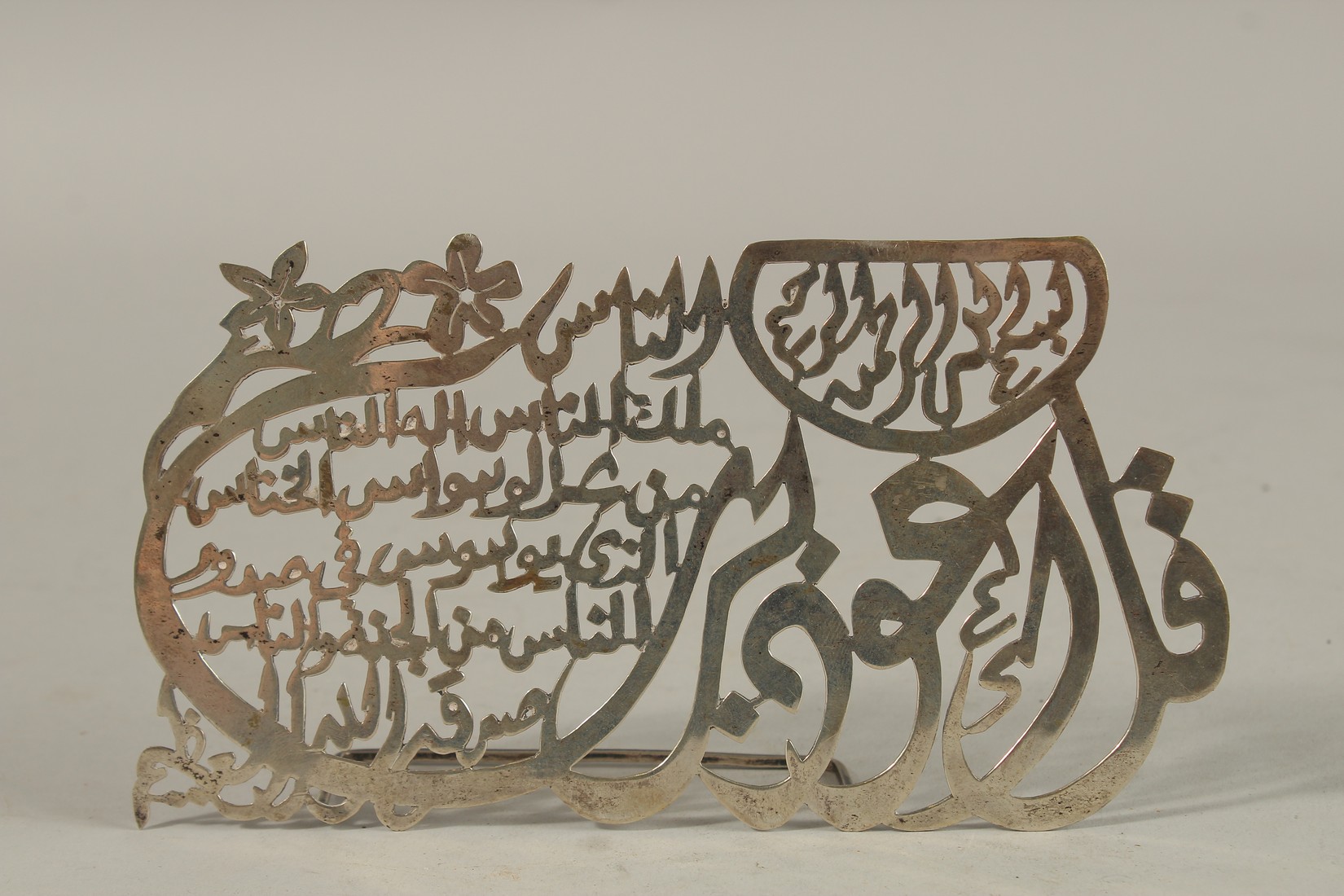 AN ISLAMIC SILVER STANDING CALLIGRAPHIC PANEL, with impressed hallmark to verso, 18cm wide.