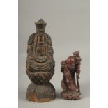 A CHINESE CARVED WOOD BUDDHA SEATED UPON A LOTUS BASE, with traces of gilt, 31cm high, together with