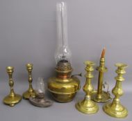 Collection of brass candlesticks, oil lamp and a small metal oil lamp in the shape of a slipper