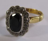 14ct gold sapphire and diamond ring - sapphire approx. 8mm x 5mm surrounded by 14 diamonds - ring