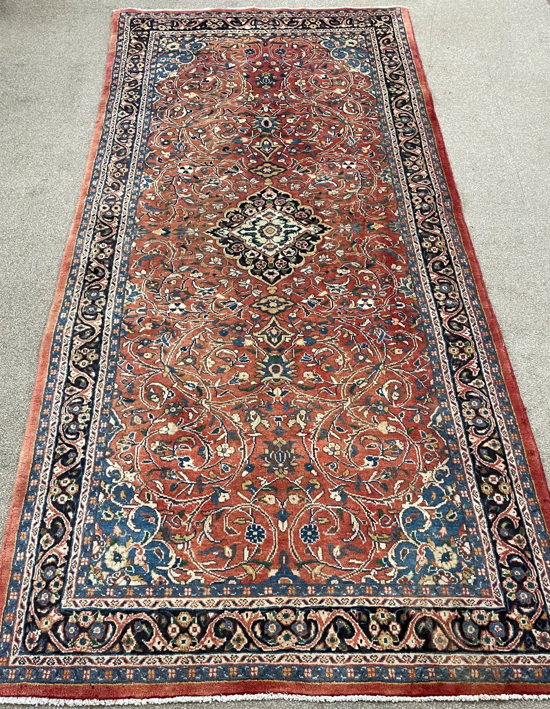 Washed red ground full pile Persian Sarouk runner with floral medallion 340cm by 160cm