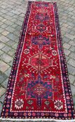 Red & blue ground Persian Heriz runner with cross medallion design 340cm by 94cm