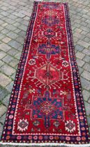 Red & blue ground Persian Heriz runner with cross medallion design 340cm by 94cm