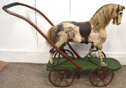 Vintage horse on wheels, piebald decoration. The total length is 90cm, the green base has a length