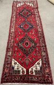 Red ground Persian wool pile hand woven runner 2.92m by 0.97m