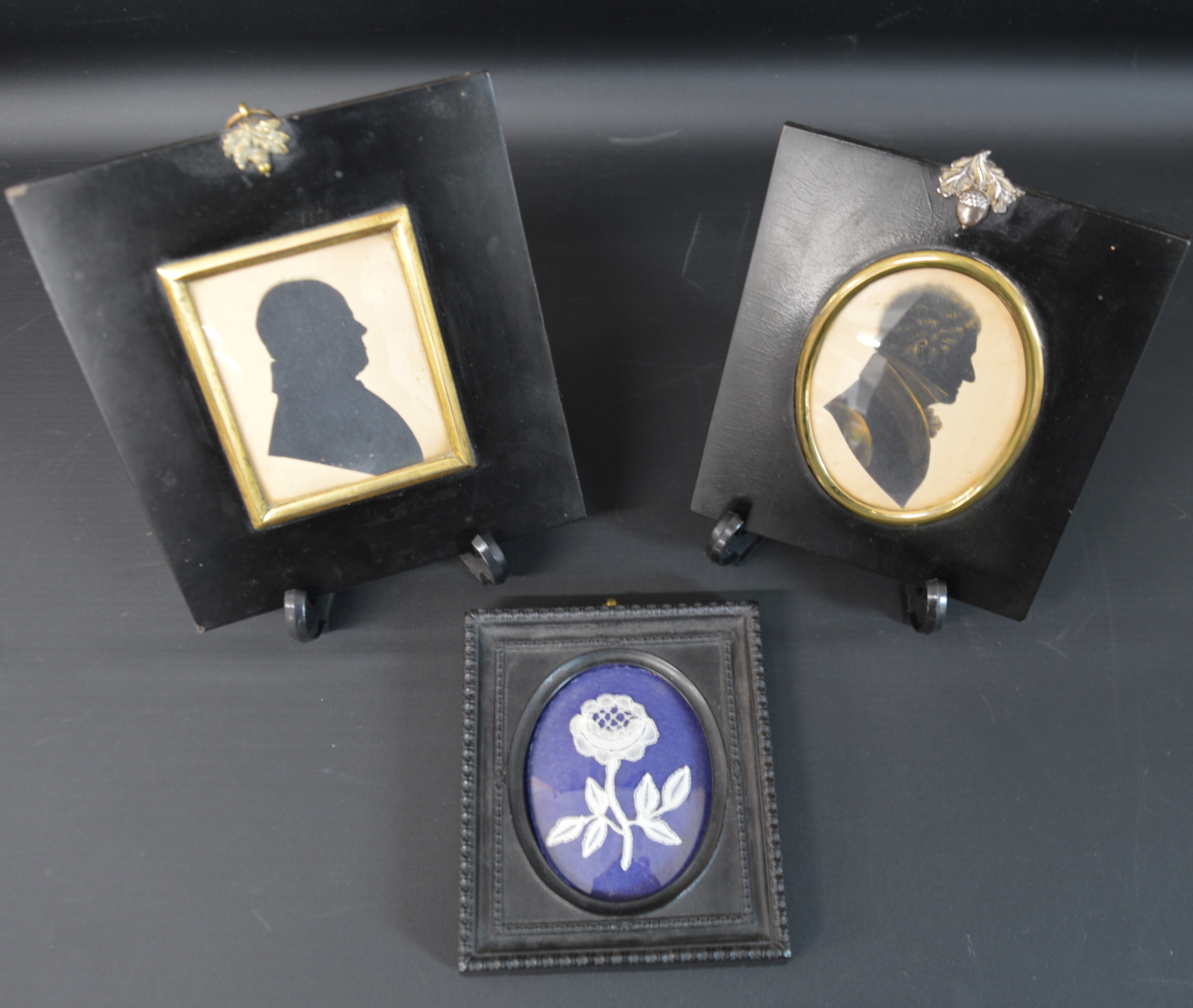 2 nineteenth century framed painted male silhouettes in ebonised frames with acorn hanging