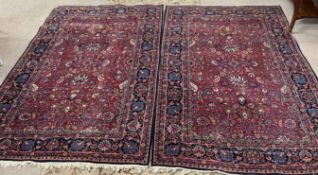 Pair of red and blue ground Persian rugs 220cm by 140cm