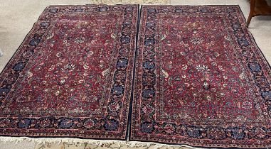 Pair of red and blue ground Persian rugs 220cm by 140cm