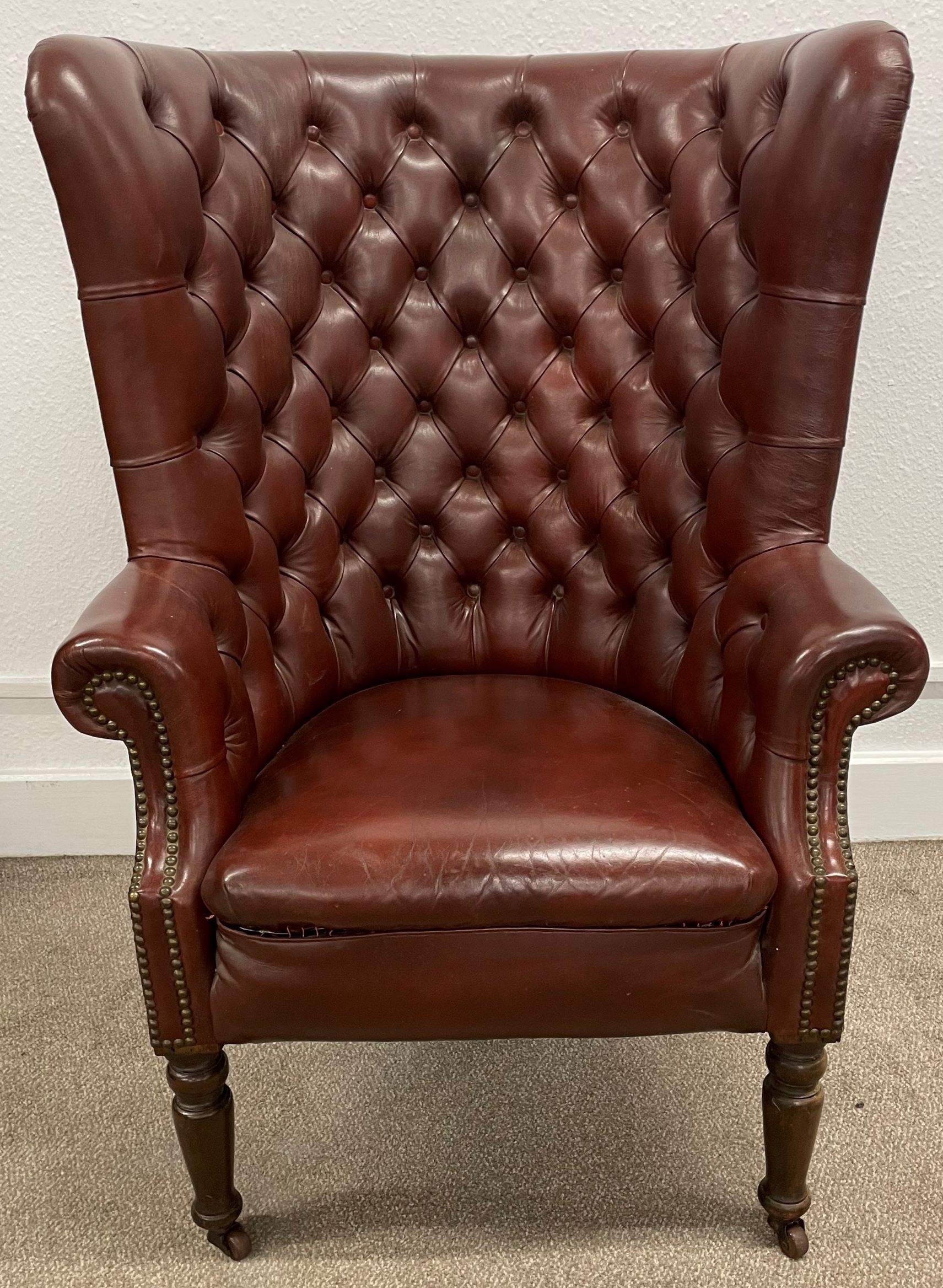 Possibly late 19th century leather button back barrel armchair on turned legs