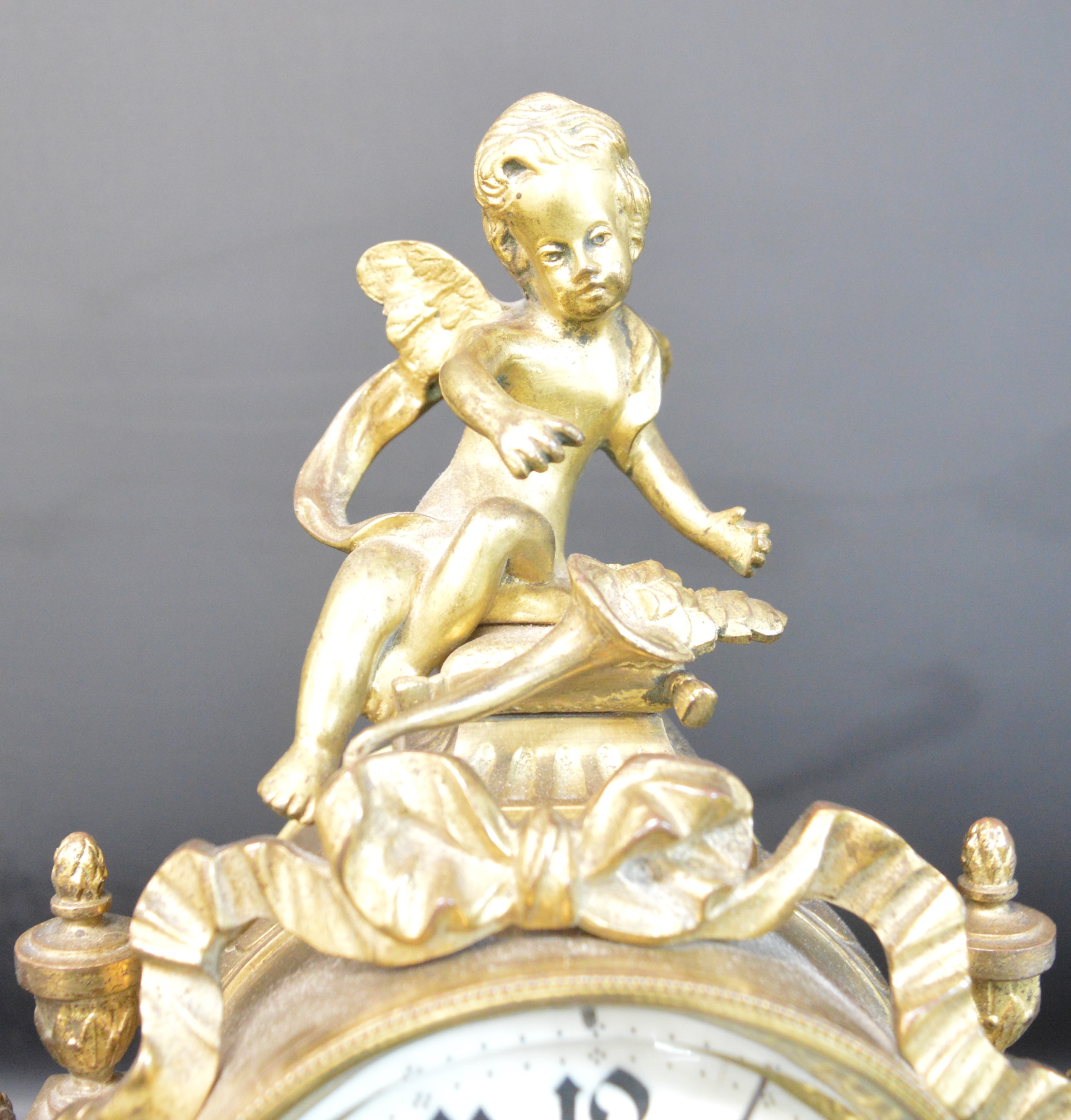 Early 20th century decorative gilt metal mantel clock surmounted by a cherub, 22cm w x 33cm h - Image 2 of 2