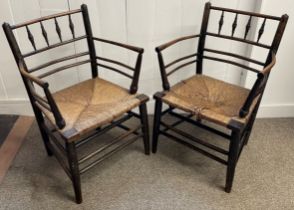 Pair of 19th century William Morris Sussex Carver chairs in ebonised beech & elm with rush seats.