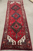 Red ground Persian wool pile hand woven runner 2.92m by 0.97m