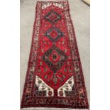 Red ground Persian wool pile hand woven runner 2.92m by 0.97m